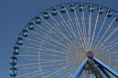 Photo of Amusement park. Beautiful Ferris wheel against blue sky, low angle view