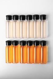 Bottles of cosmetic products on white background, flat lay