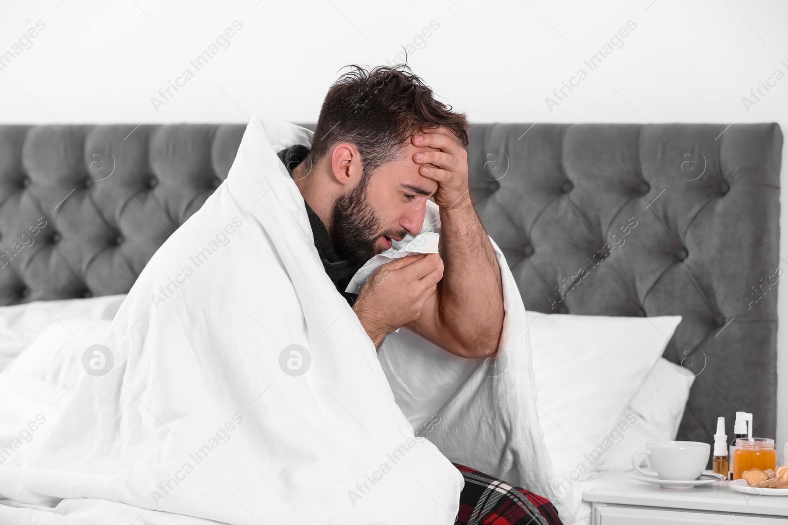 Photo of Ill man suffering from cough at home