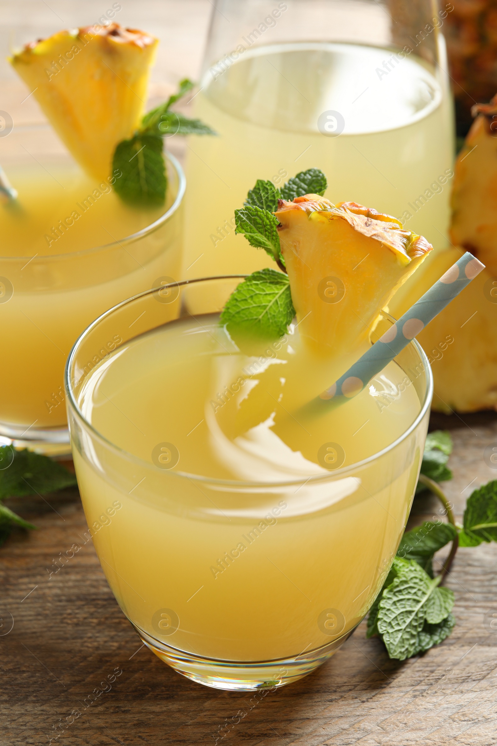 Photo of Delicious fresh pineapple juice with mint on wooden table, closeup