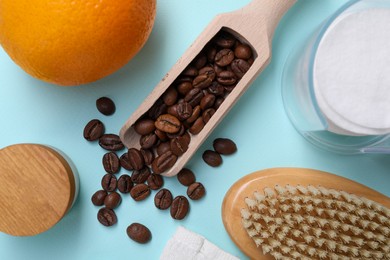 Photo of Coffee beans, orange and brush on light blue background, flat lay. Anti cellulite treatment