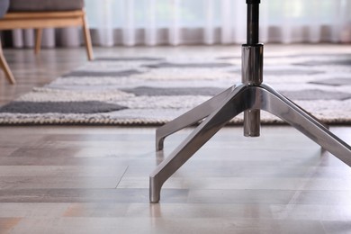 Photo of Modern office chair on wooden floor, closeup