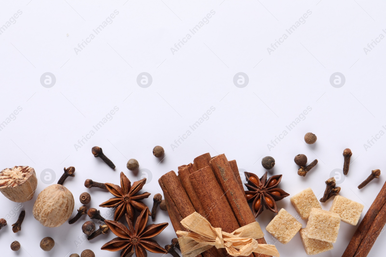 Photo of Different spices and nuts on white table, flat lay. Space for text