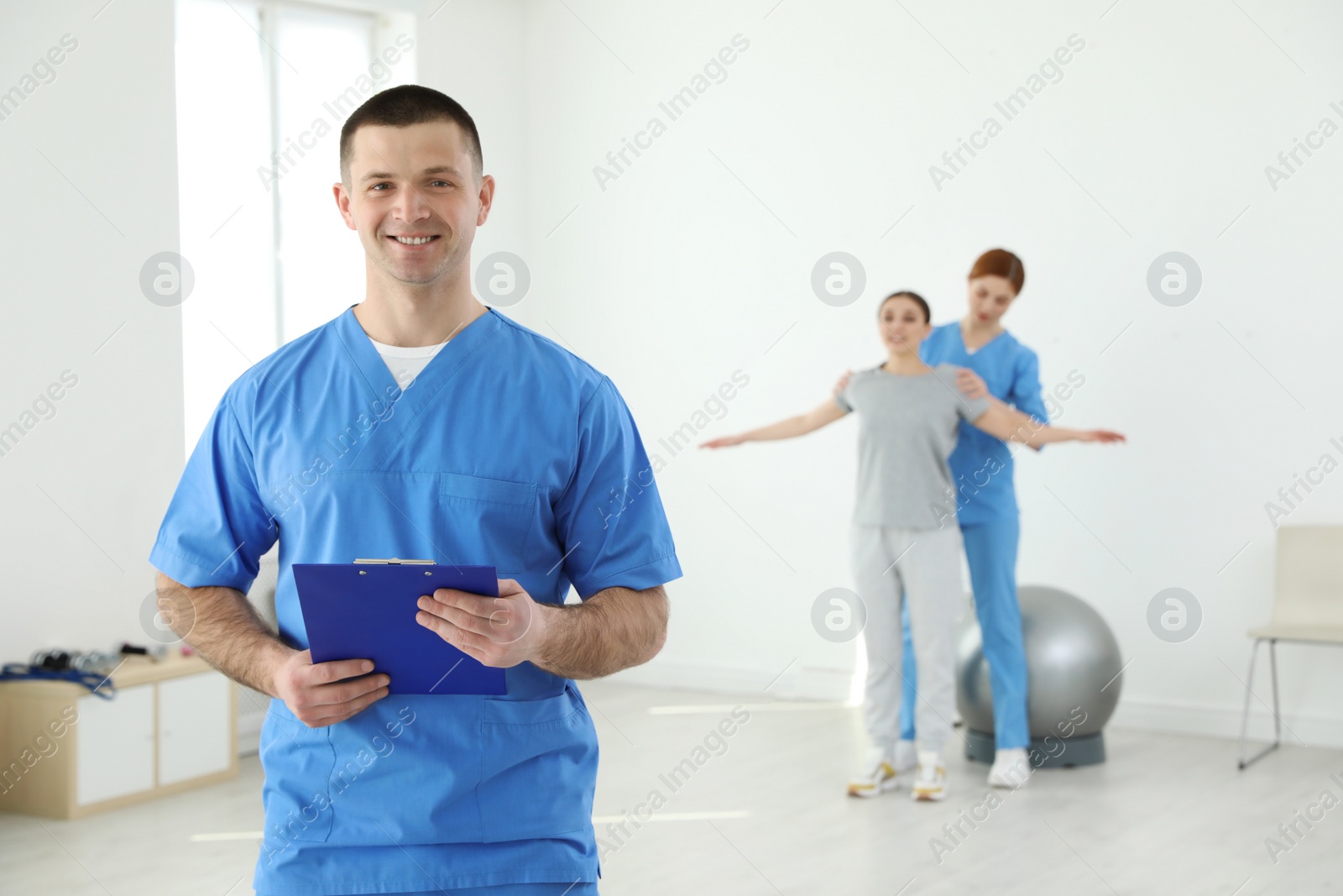 Photo of Portrait of professional physiotherapist with clipboard in rehabilitation center. Space for text