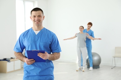 Photo of Portrait of professional physiotherapist with clipboard in rehabilitation center. Space for text