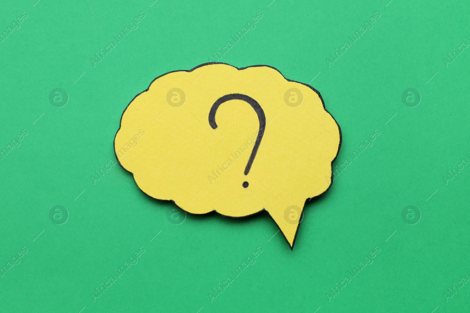 Photo of Paper speech bubble with question mark on green background, top view