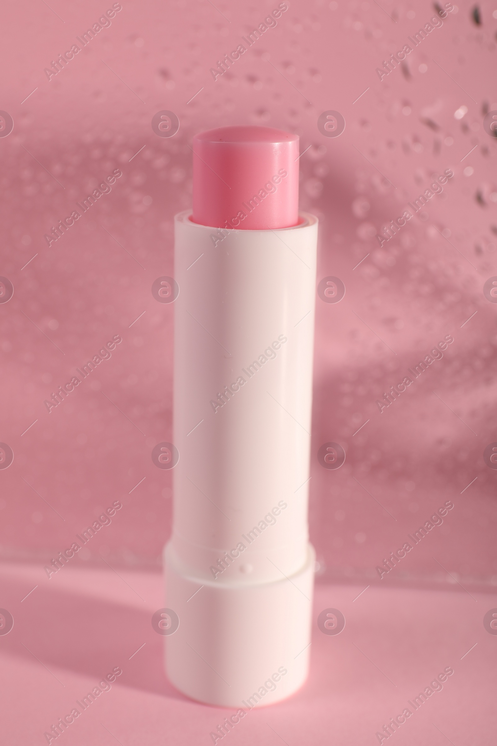 Photo of One lip balm on pink background, closeup