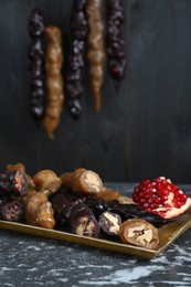 Delicious sweet churchkhelas and pomegranate on textured table
