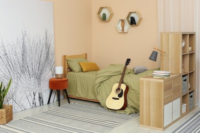 Photo of Stylish teenager's room interior with comfortable bed and guitar