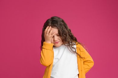 Photo of Portrait of cute little girl on pink background