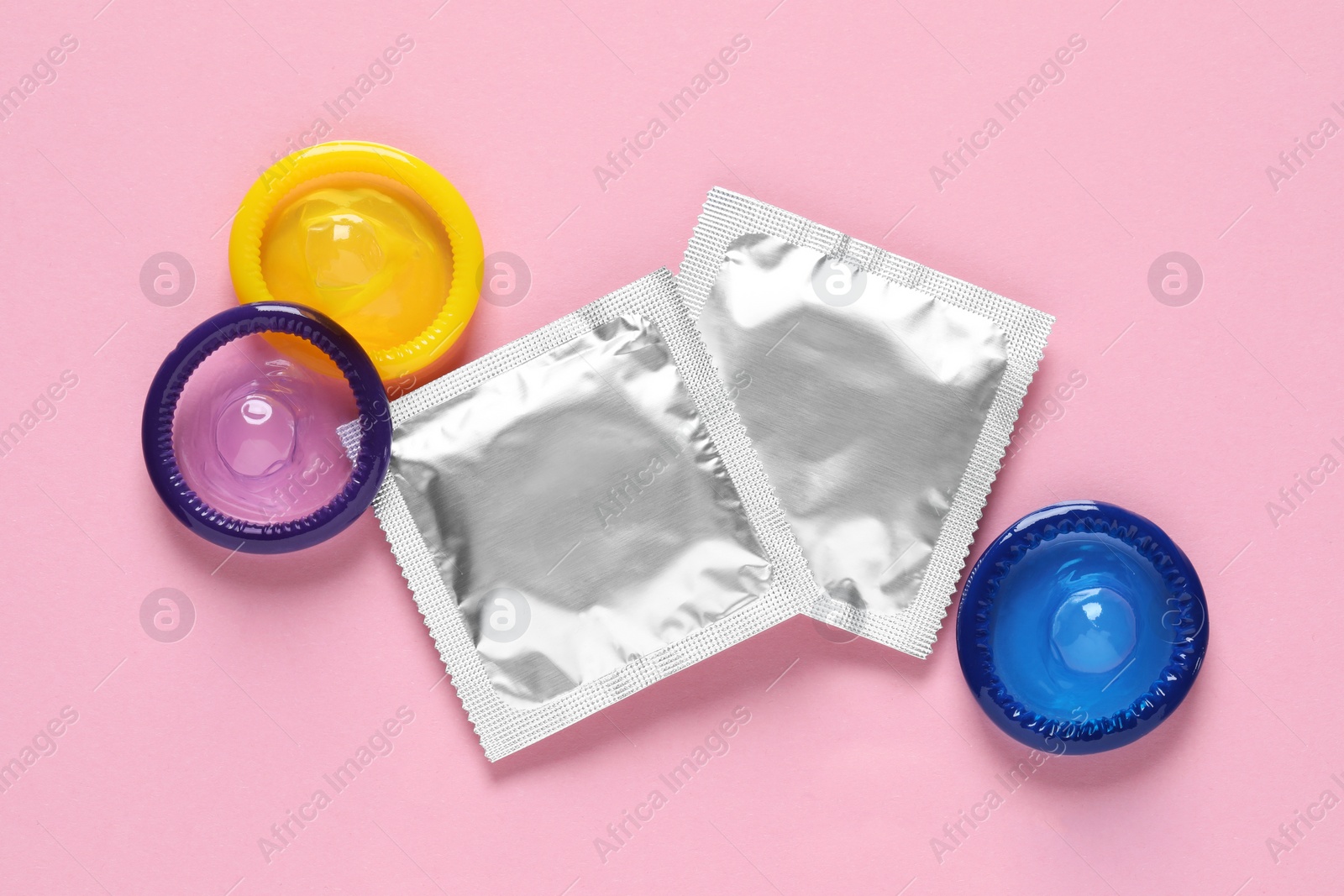 Photo of Condoms on pink background, flat lay. Safe sex