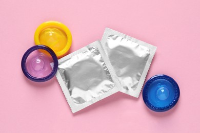 Condoms on pink background, flat lay. Safe sex