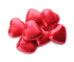 Photo of Heart shaped chocolate candies in red foil on white background, top view