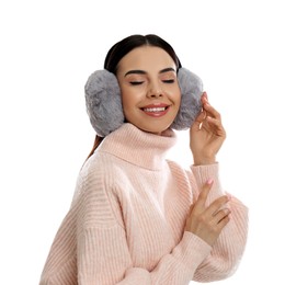 Beautiful young woman wearing earmuffs on white background