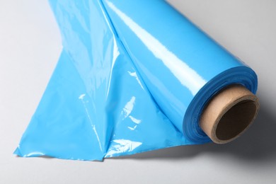 Photo of Roll of plastic stretch wrap film on white background, closeup