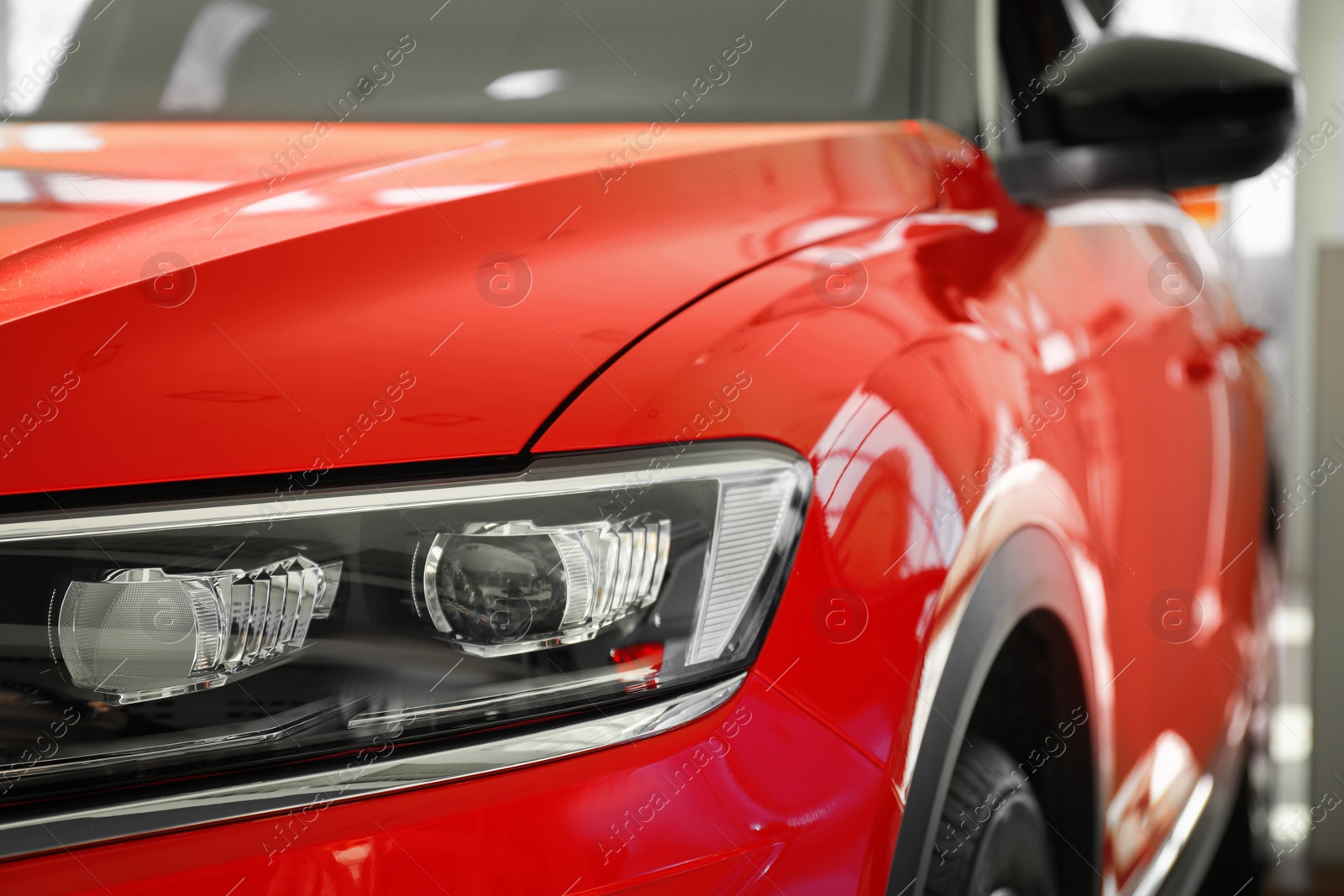 Photo of New luxury car in modern auto dealership, closeup