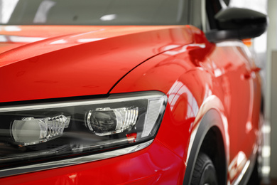 Photo of New luxury car in modern auto dealership, closeup