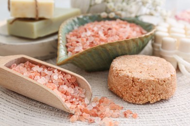 Sea salt, soap bars and dry shampoo on mat, closeup