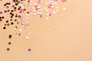 Photo of Shiny bright glitter on beige background. Space for text