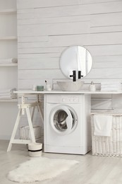 Stylish bathroom interior with modern washing machine