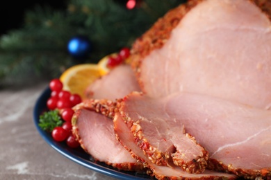 Photo of Plate with Christmas ham on grey table, closeup