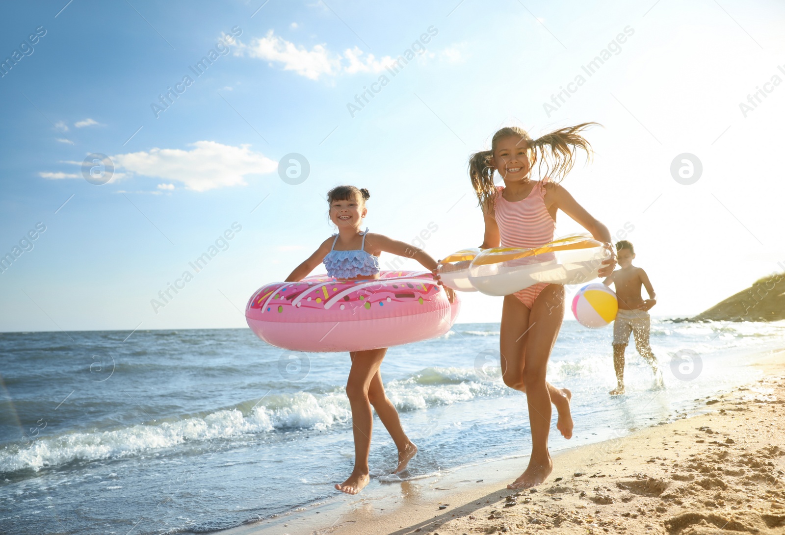 Photo of Cute children enjoying sunny day at beach. Summer camp