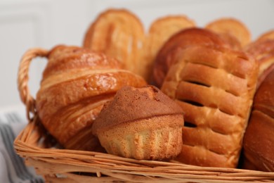 Wicker basket with different tasty freshly baked pastries, closeup