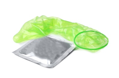 Unrolled green condom and package on white background. Safe sex