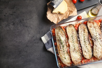 Photo of Flat lay composition with baked eggplant, tomatoes and cheese in dishware on table. Space for text