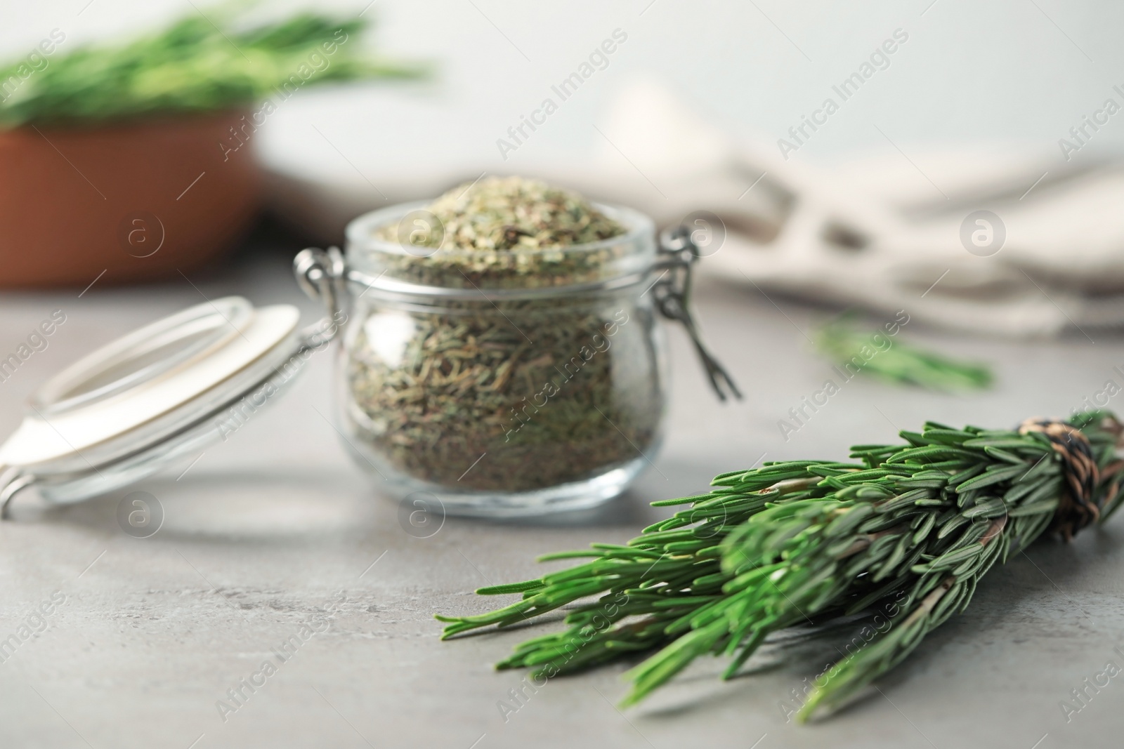 Photo of Fresh twigs and dried rosemary on grey table