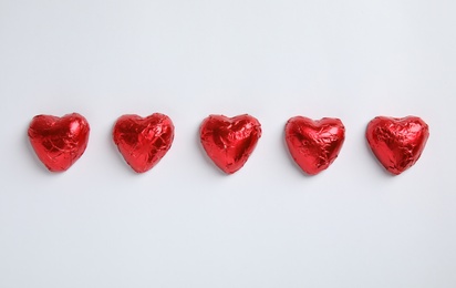 Heart shaped chocolate candies on white background, flat lay. Valentine's day treat