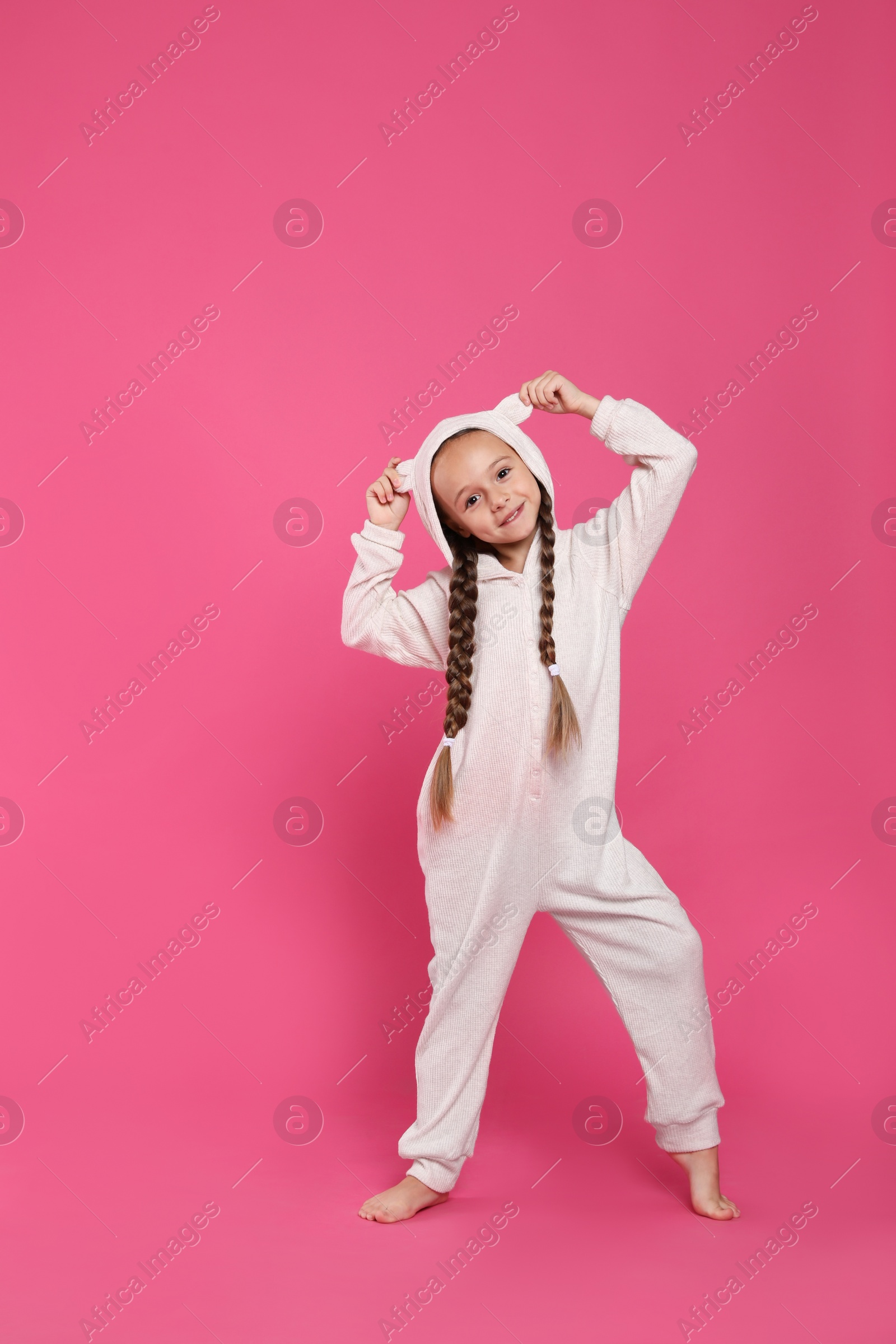 Photo of Cute girl wearing pajamas on pink background