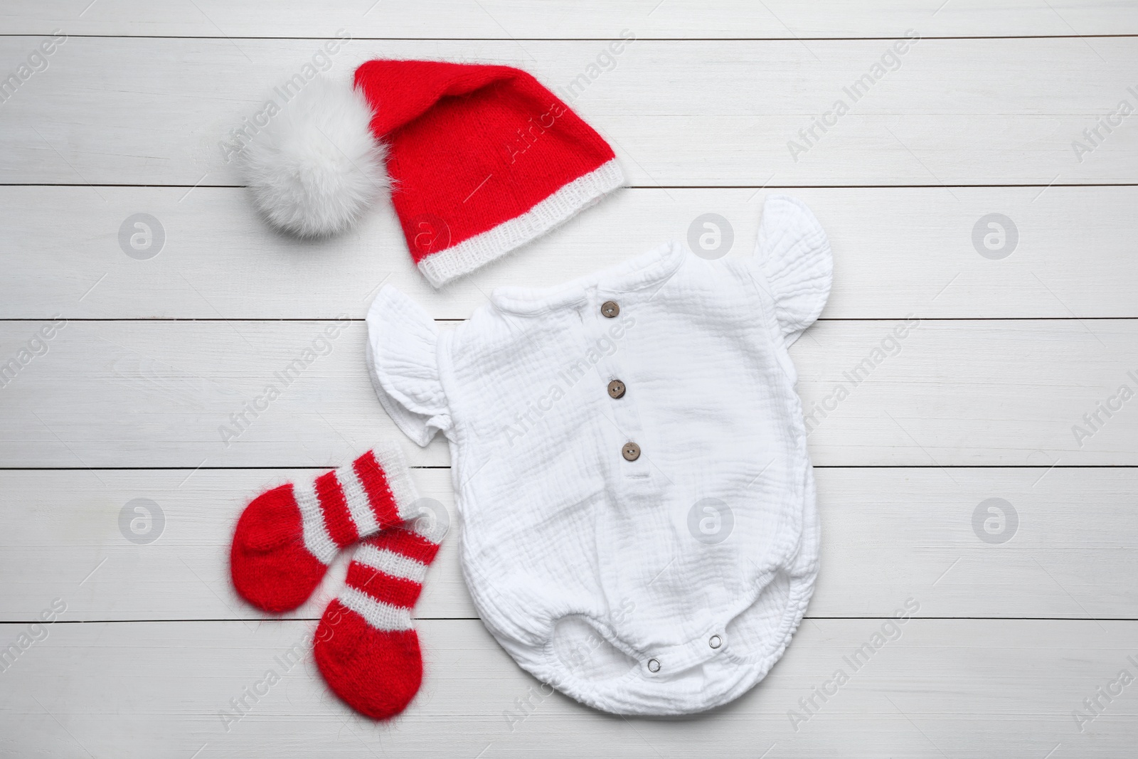 Photo of Flat lay composition with child's clothes on white wooden table