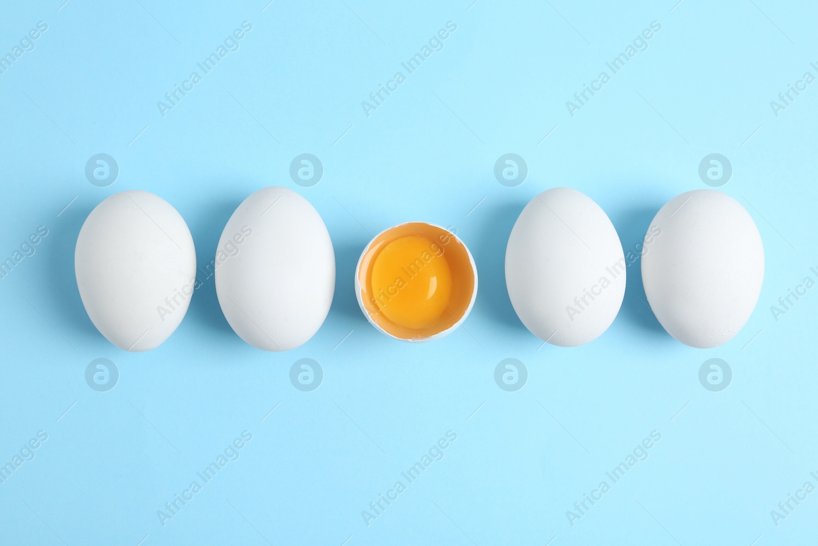 Photo of Fresh raw chicken eggs on light blue background, flat lay