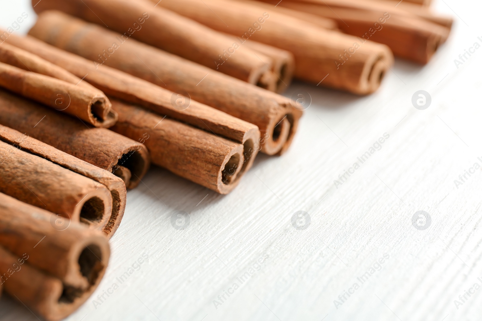 Photo of Aromatic cinnamon sticks on wooden background