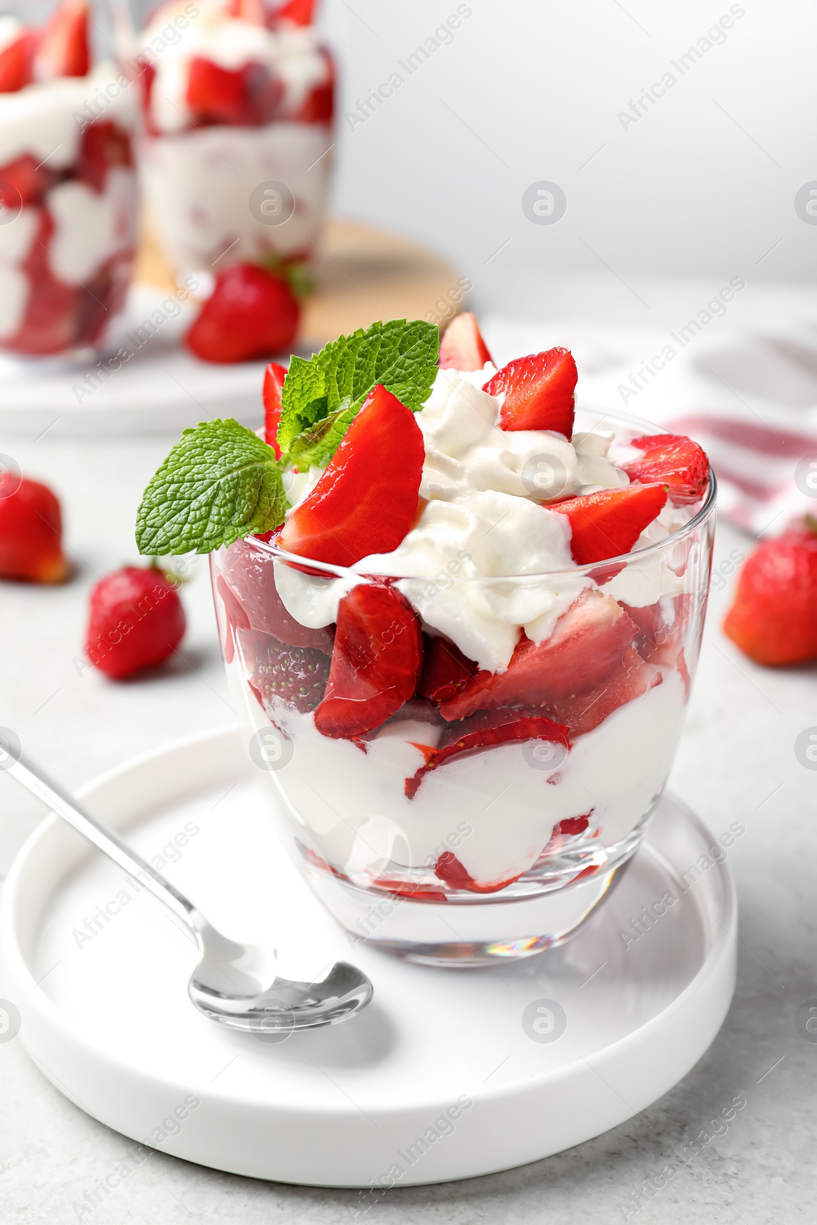 Photo of Delicious strawberries with whipped cream served on light grey table