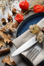 Festive table setting with autumn decor on wooden background, closeup
