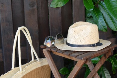 Photo of Different stylish beach accessories near wooden fence