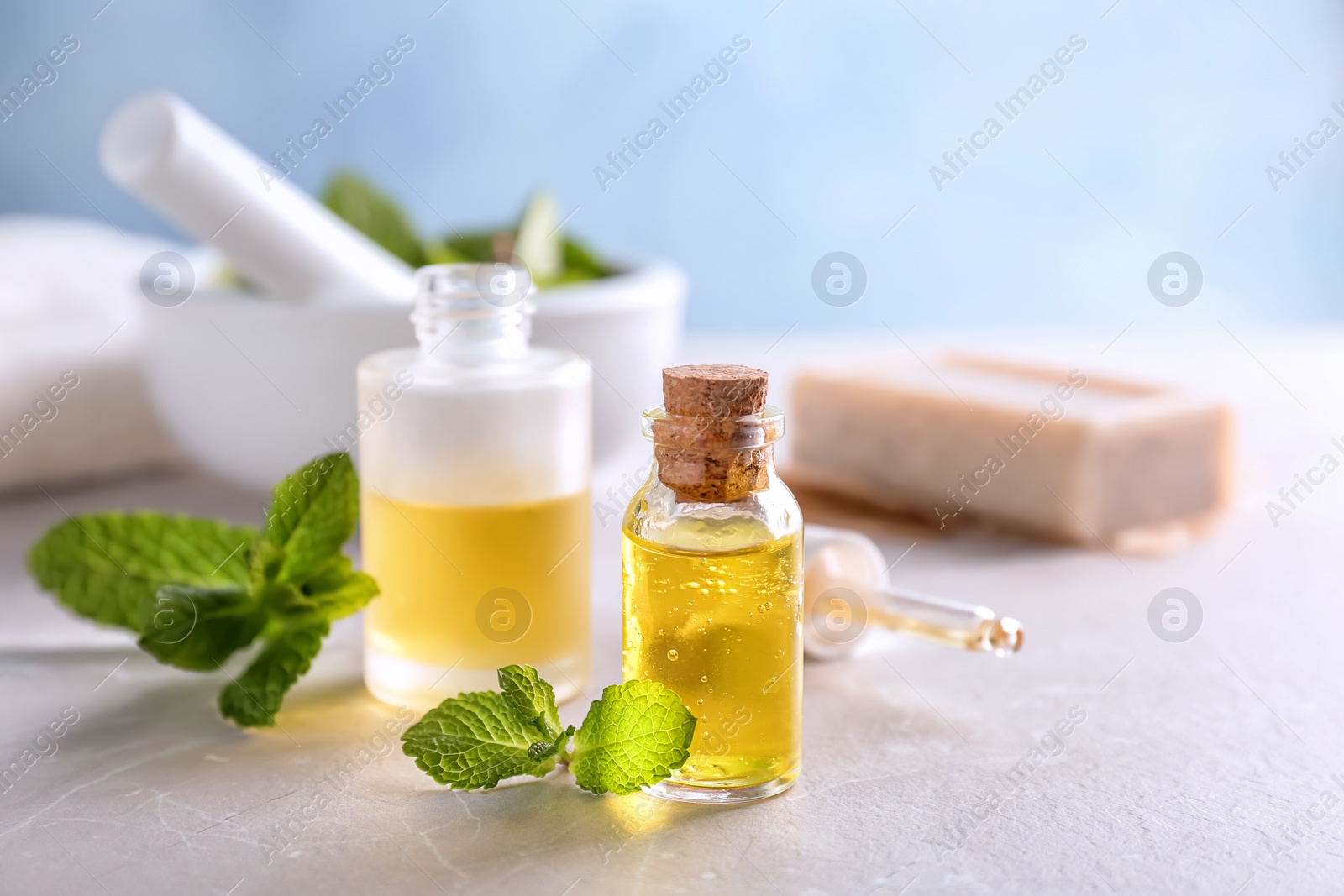 Photo of Bottles with mint essential oil on table