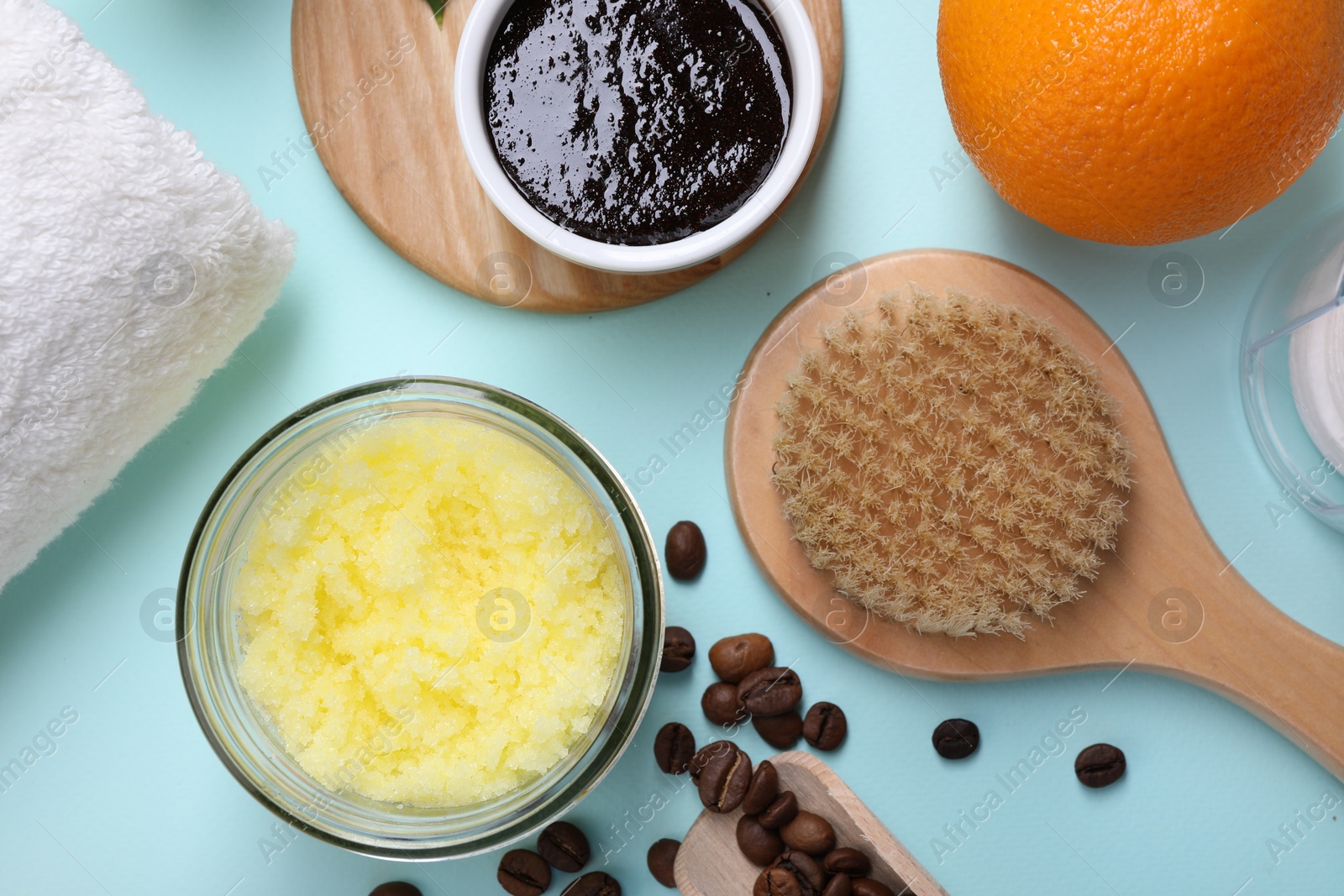 Photo of Flat lay composition with natural body scrubs and fresh ingredients on light blue background. Anti cellulite treatment