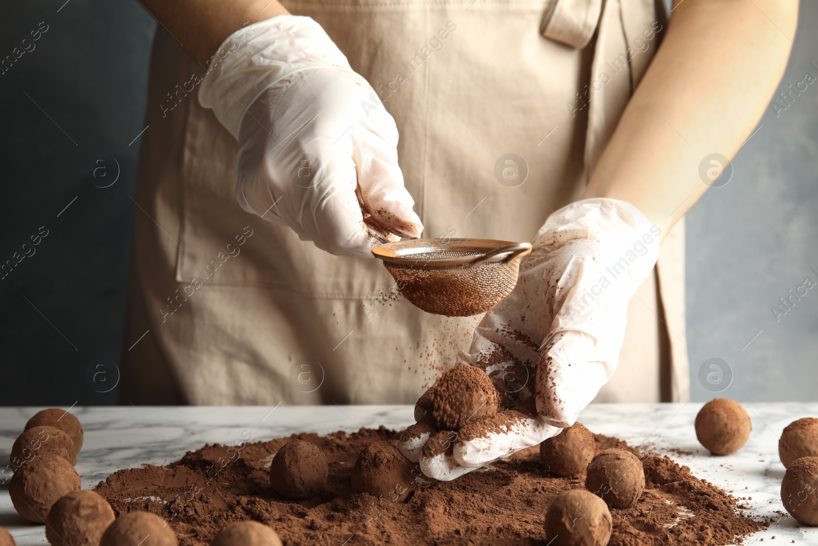 Photo of Woman preparing tasty chocolate truffles at table, closeup