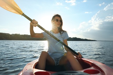 Photo of Beautiful woman kayaking on river. Summer activity