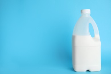 Photo of Gallon bottle of milk on light blue background. Space for text