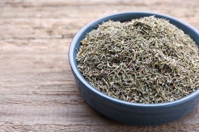 Plate with dried thyme on wooden table, closeup