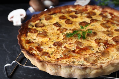 Photo of Delicious homemade mushroom pie on black table, closeup