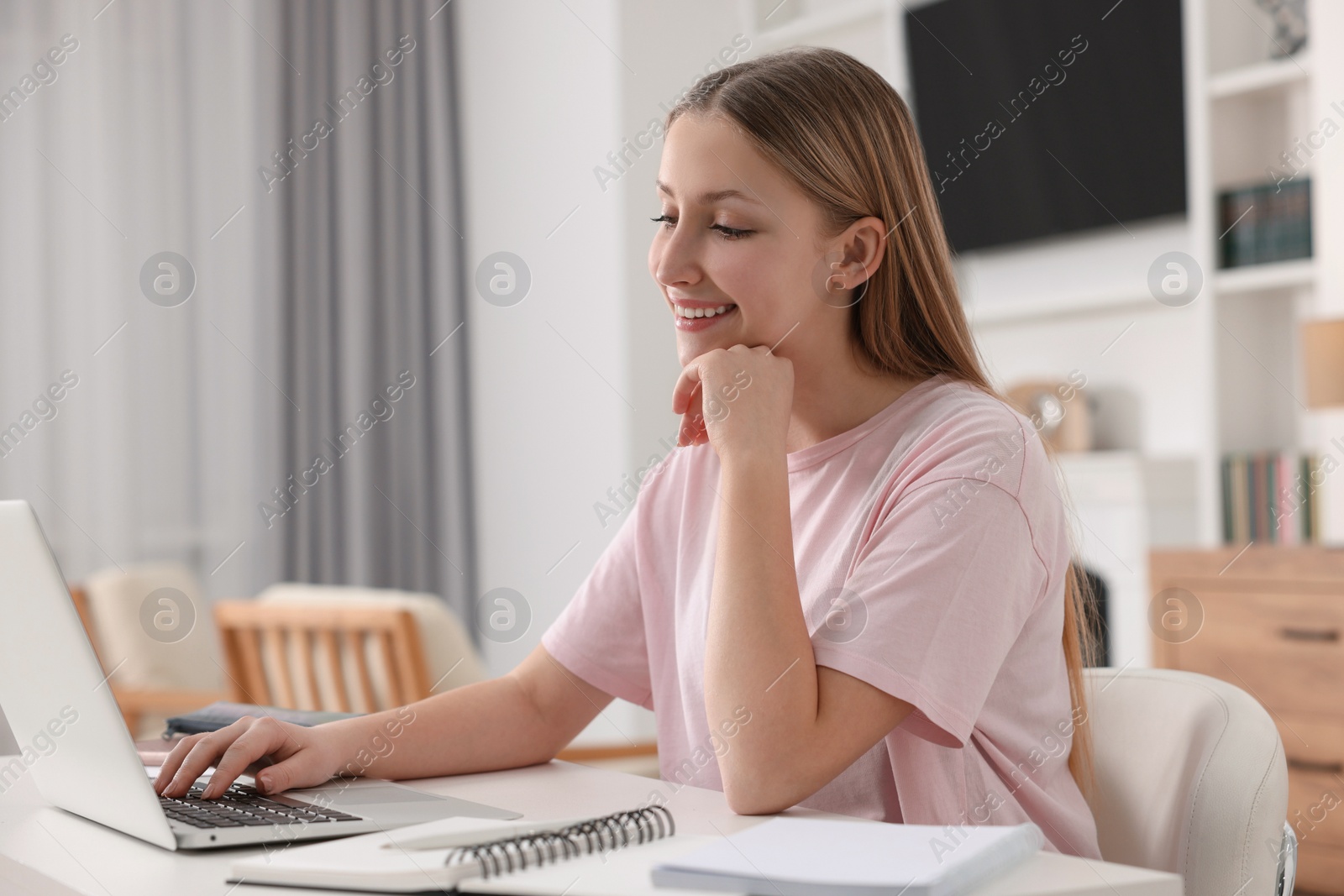 Photo of Online learning. Teenage girl typing on laptop at table