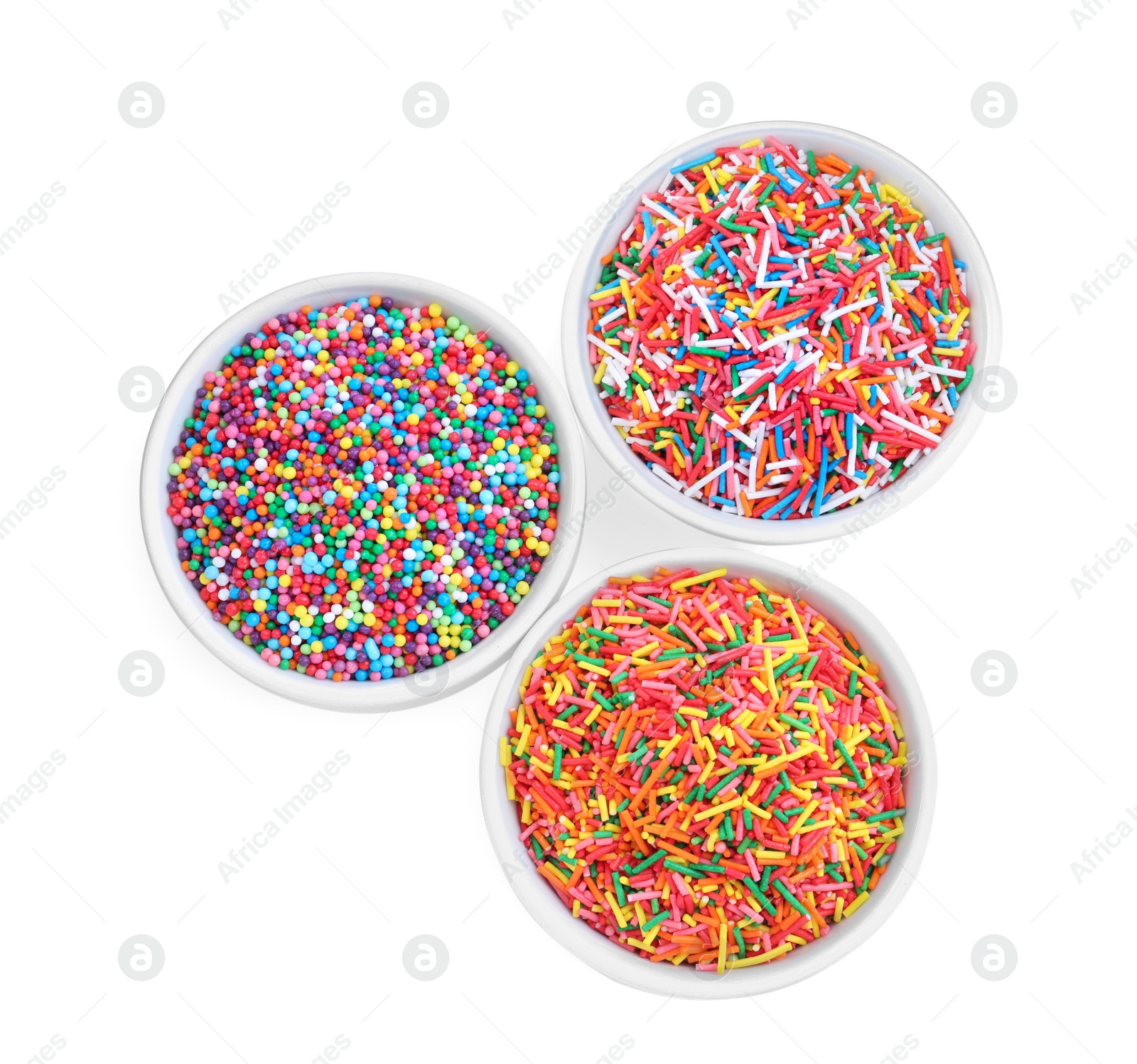 Photo of Colorful sprinkles in bowls on white background, top view. Confectionery decor