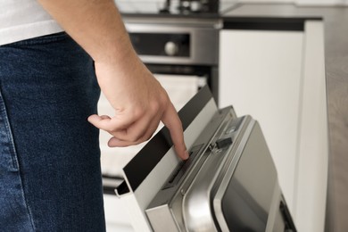 Man pushing button on dishwasher's door indoors, closeup