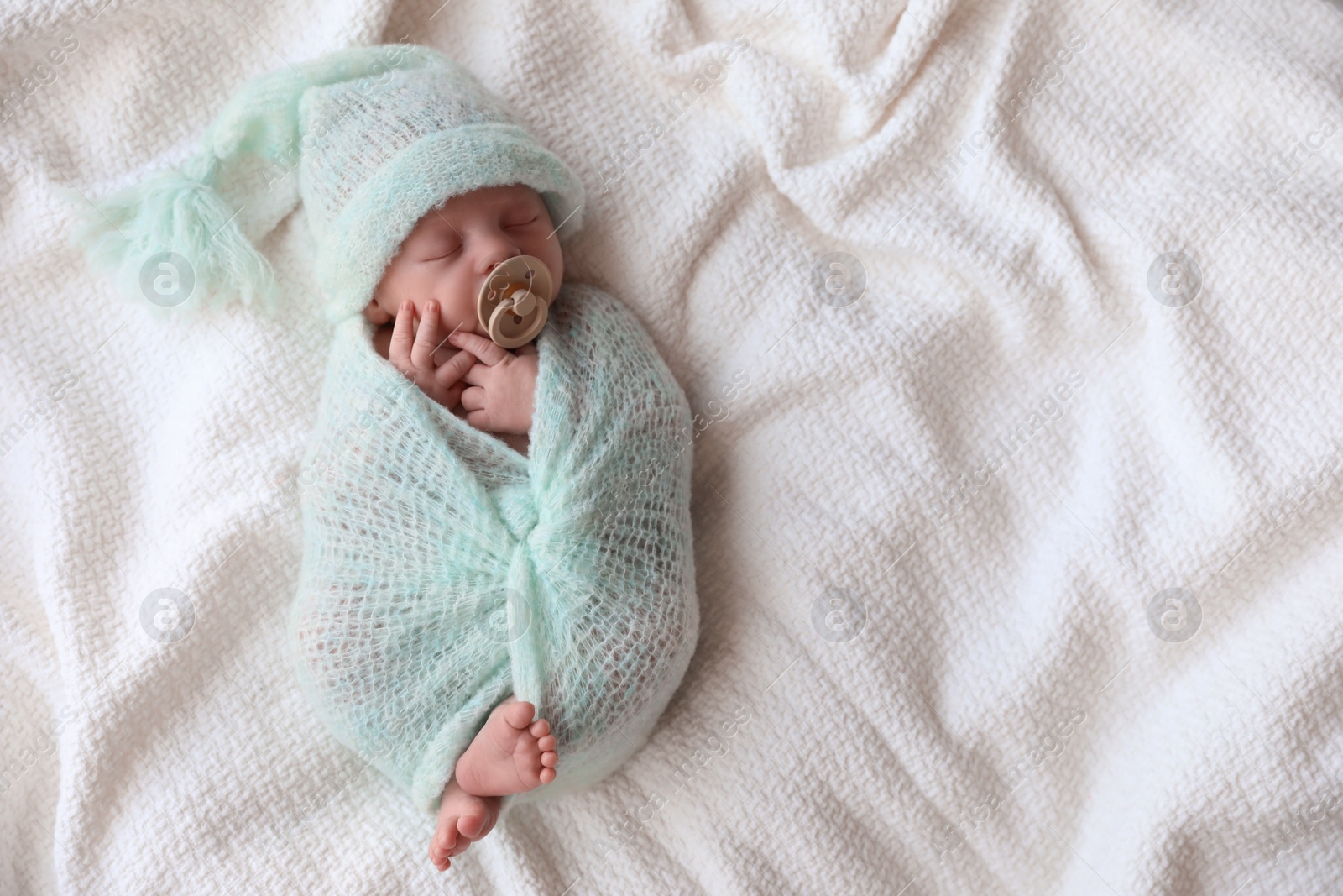 Photo of Cute newborn baby sleeping on white plaid, top view. Space for text