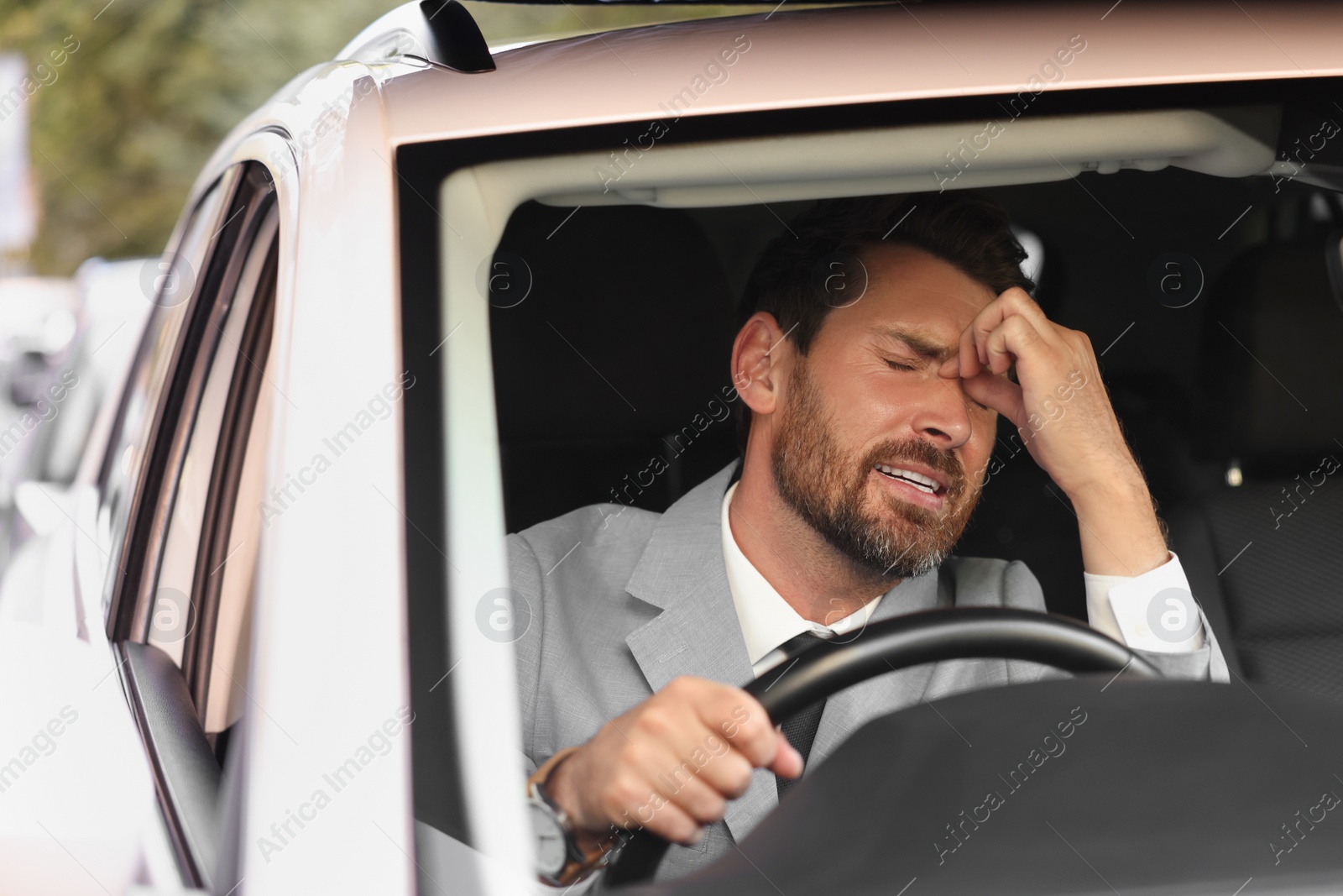 Photo of Stuck in traffic jam. Stressed driver in his car, view through windshield